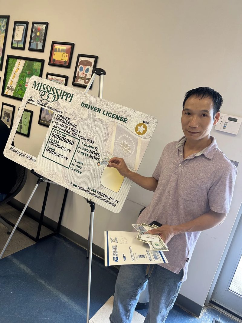 Holding a driver license beside the Mississippi new-driver photo frame at the Department of Public Safety office